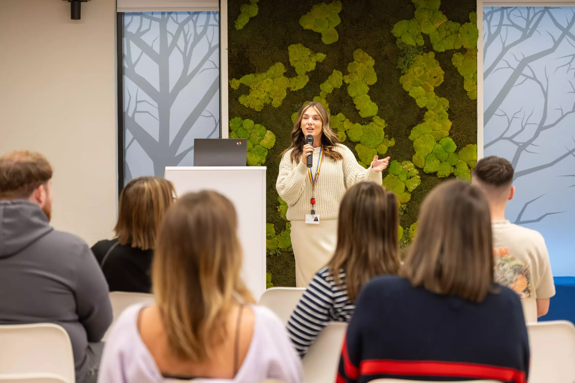 A group of employees in red jackets celebrating with winners, holding cheques