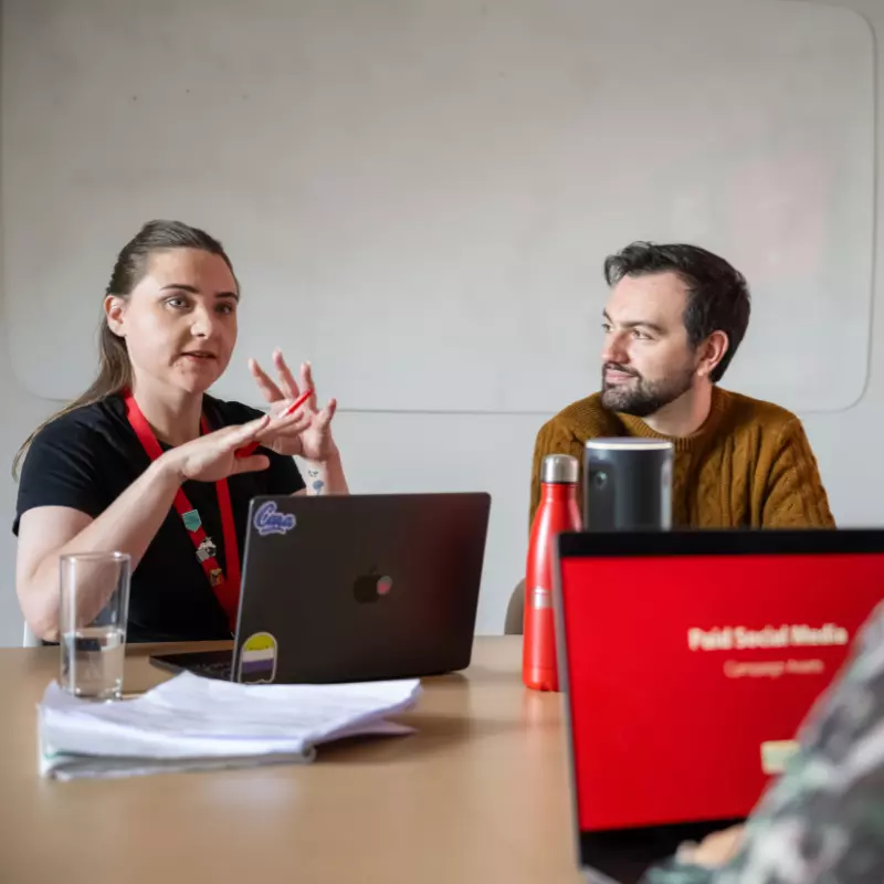 Two employees within a meeting room chatting
